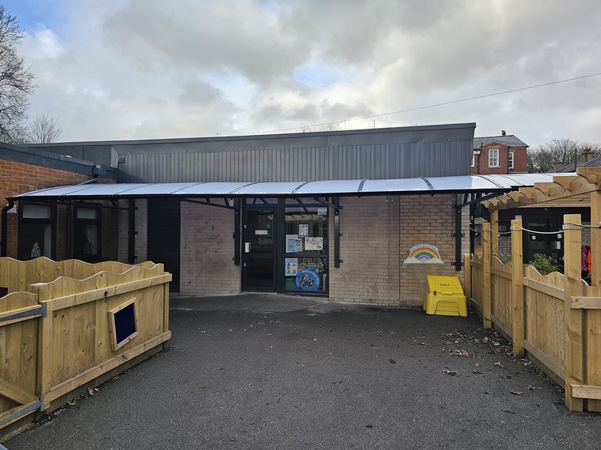 A steel playground canopy over a primary-school play area